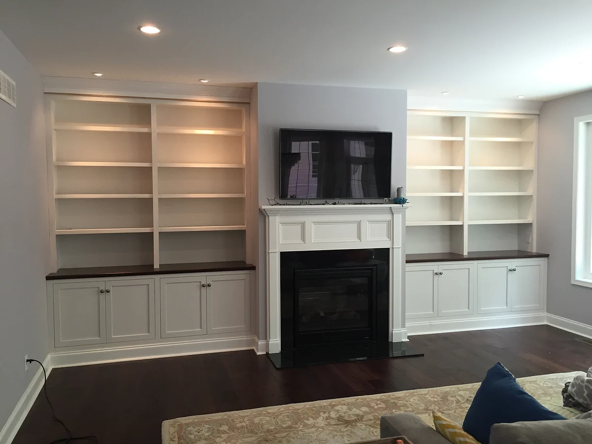 White built-in bookcases and cabinetry surrounding a fireplace