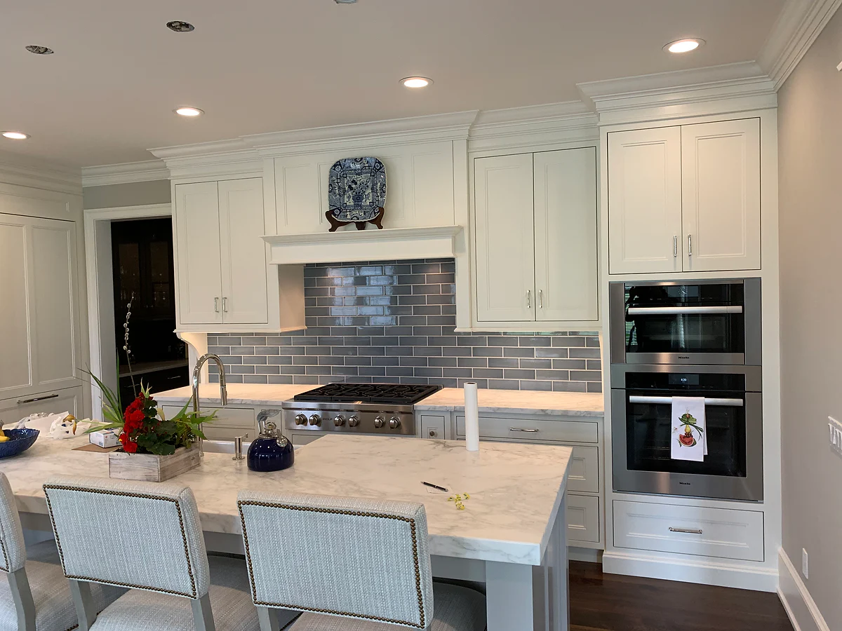 Custom kitchen cabinetry with a tiled backsplash and integrated appliances