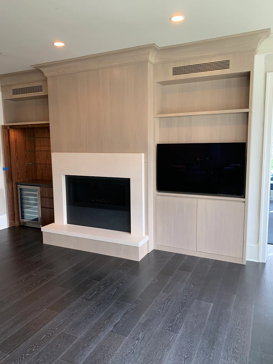 Custom fireplace wall with built-in shelving and concealed storage