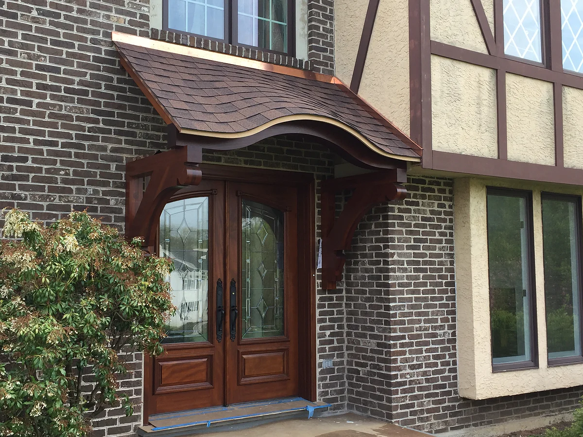 Crafted timber entry canopy on a historic Tudor-style home