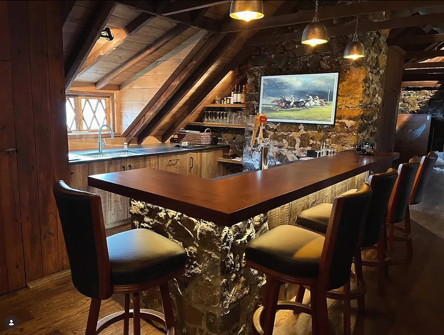 Custom bar built into a rustic stone and timber room